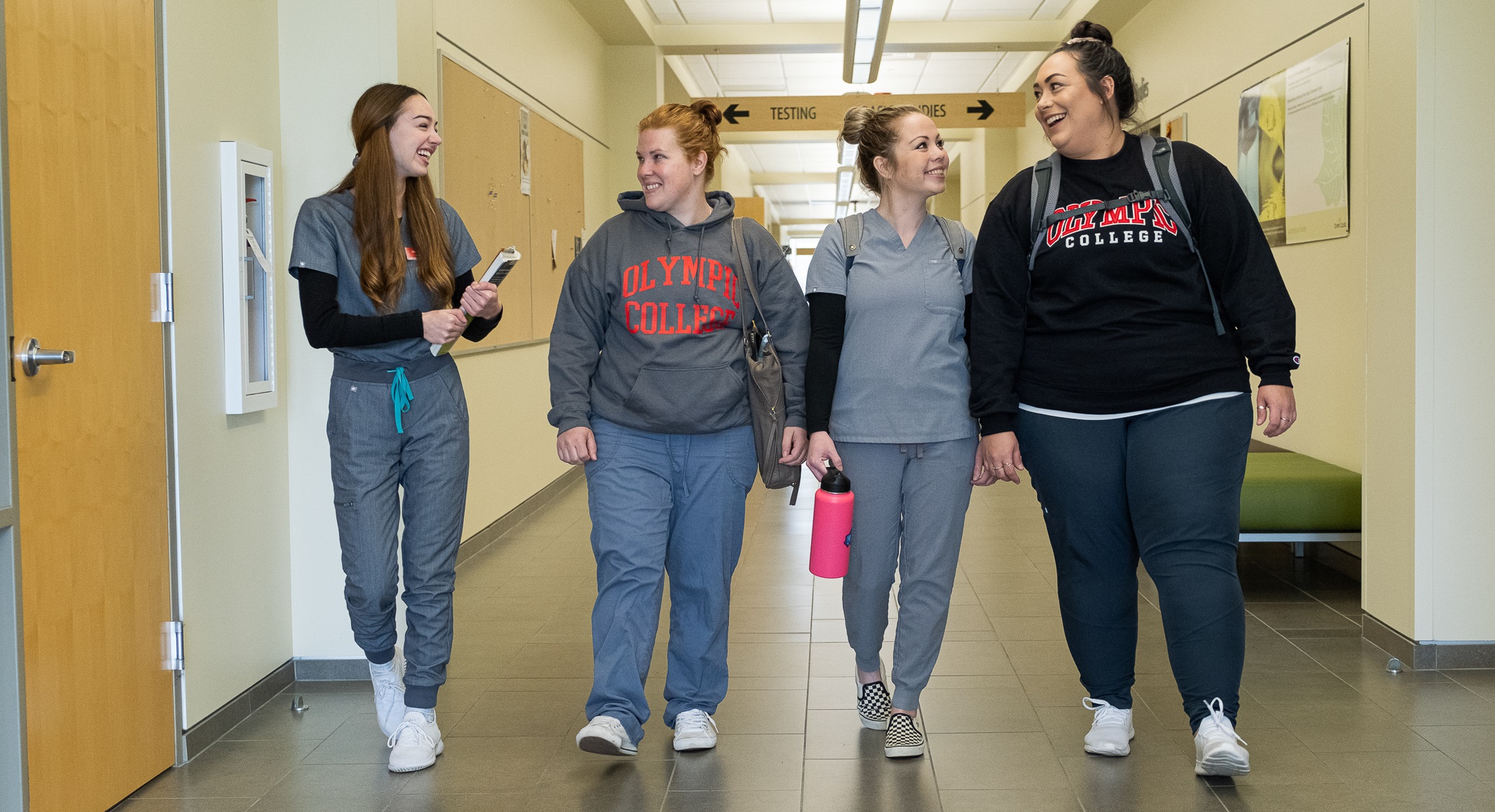 Four students walking down a hallway