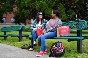 Two students on bench. 